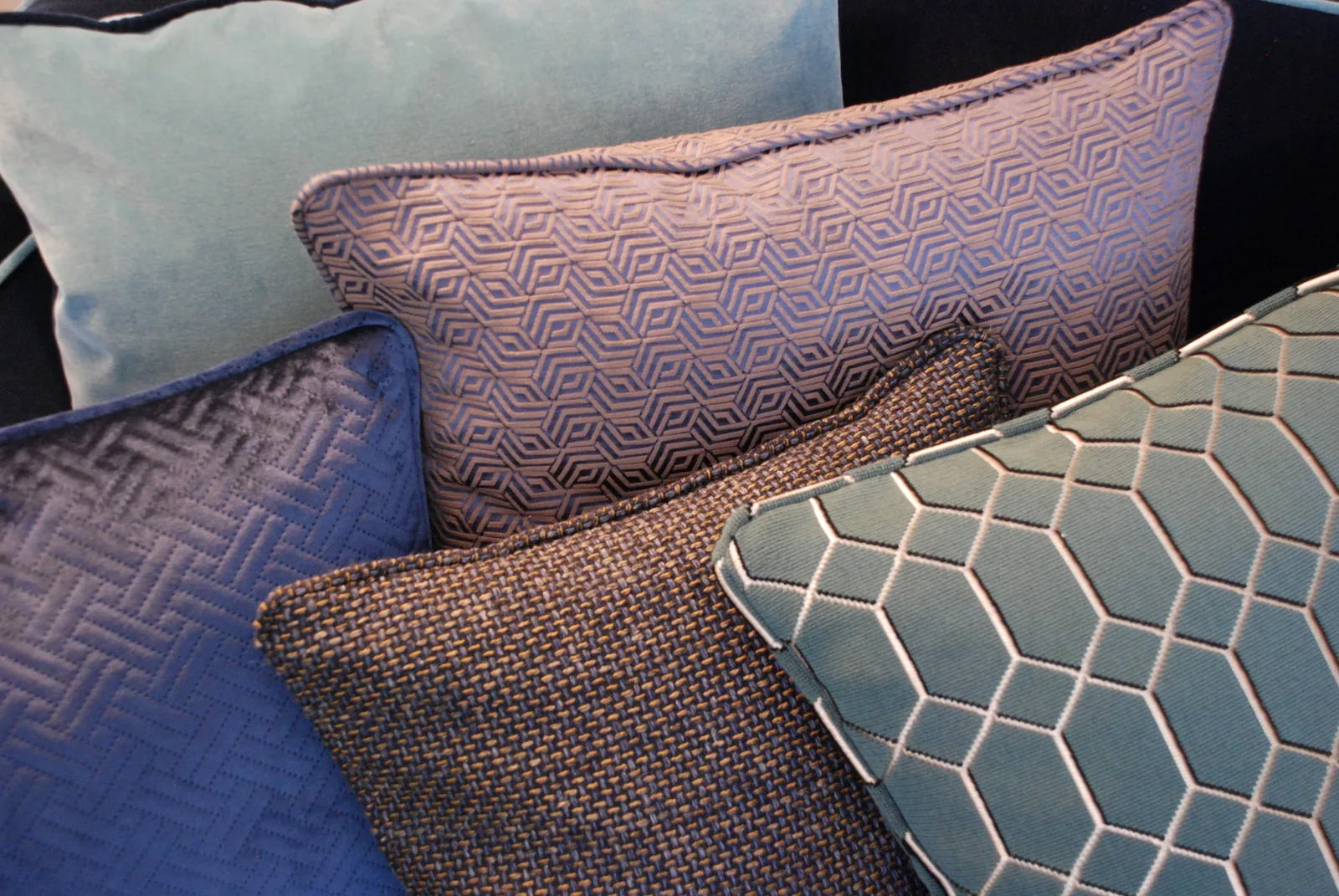Dekorative Kissen in Blau, Petrol und Grau mit geometrischen Mustern und Samt