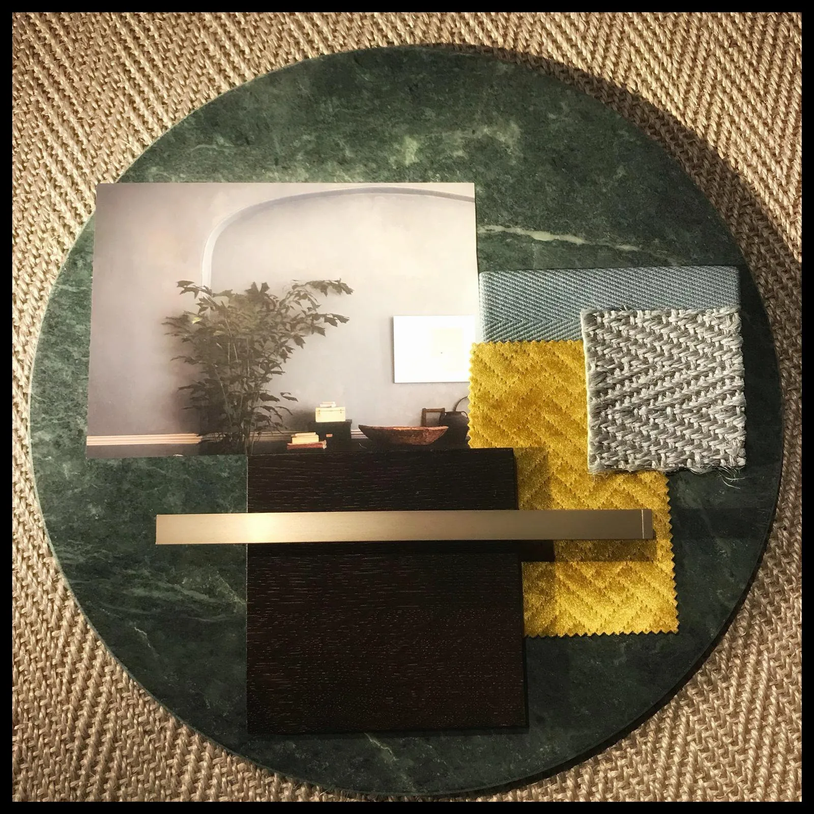 Moodboard in Grün: Stoffe mit Blattmuster, dunkles Holz, Sisal und Messing auf grünem Marmor