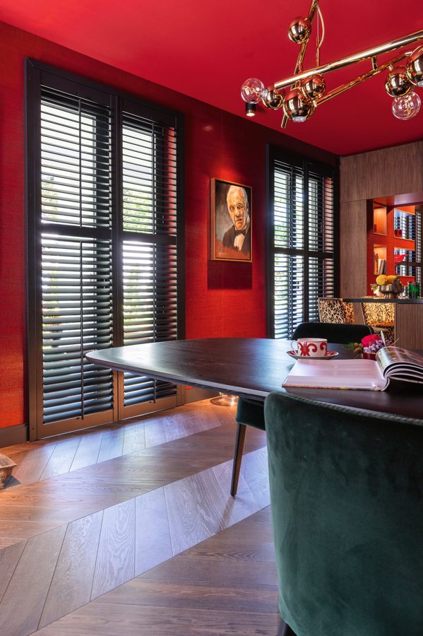 Schwarze Shutters vor einer dunkelroten Wand