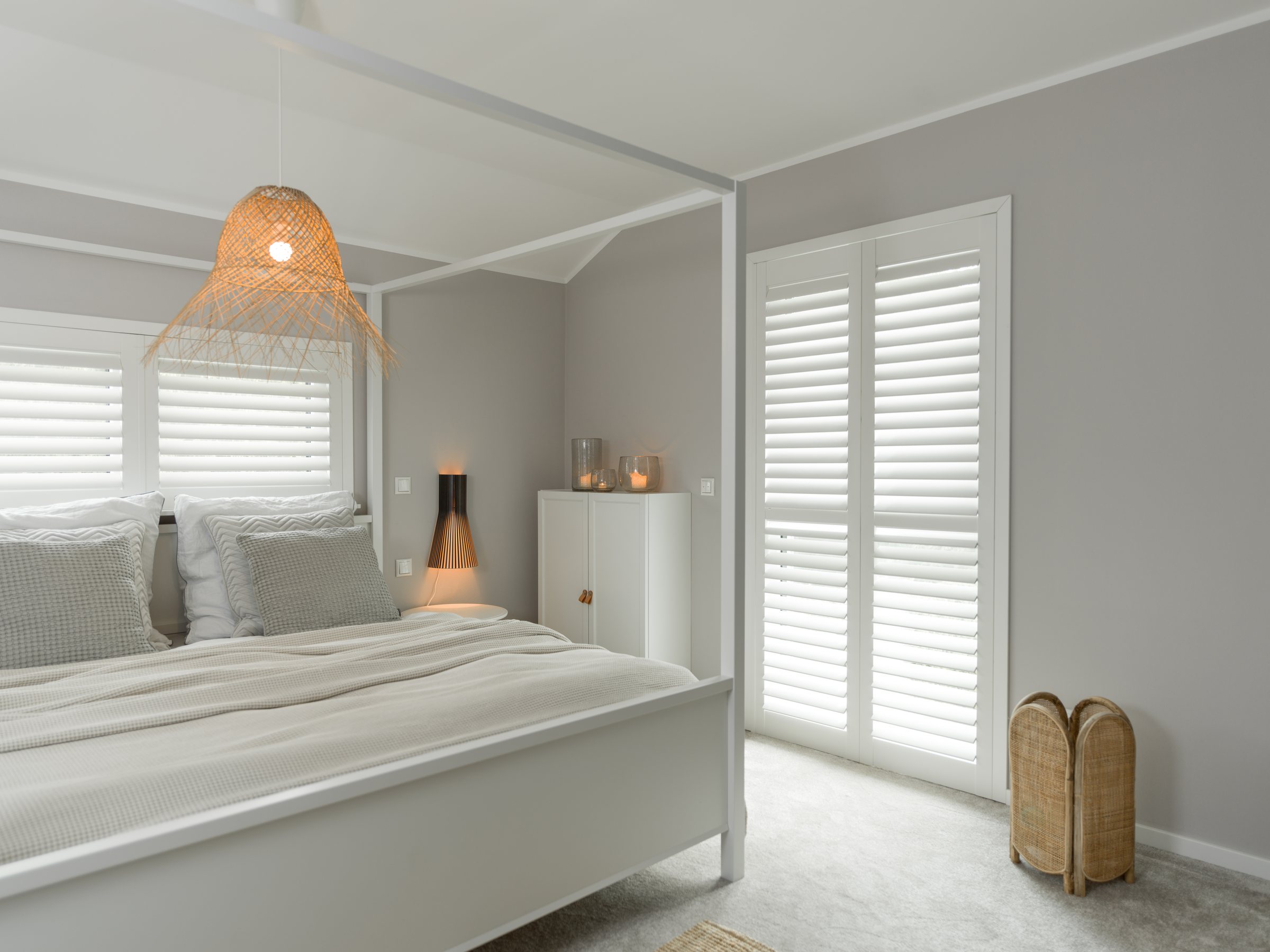 Schlafzimmer mit weißen Shutters an zwei Fenstern